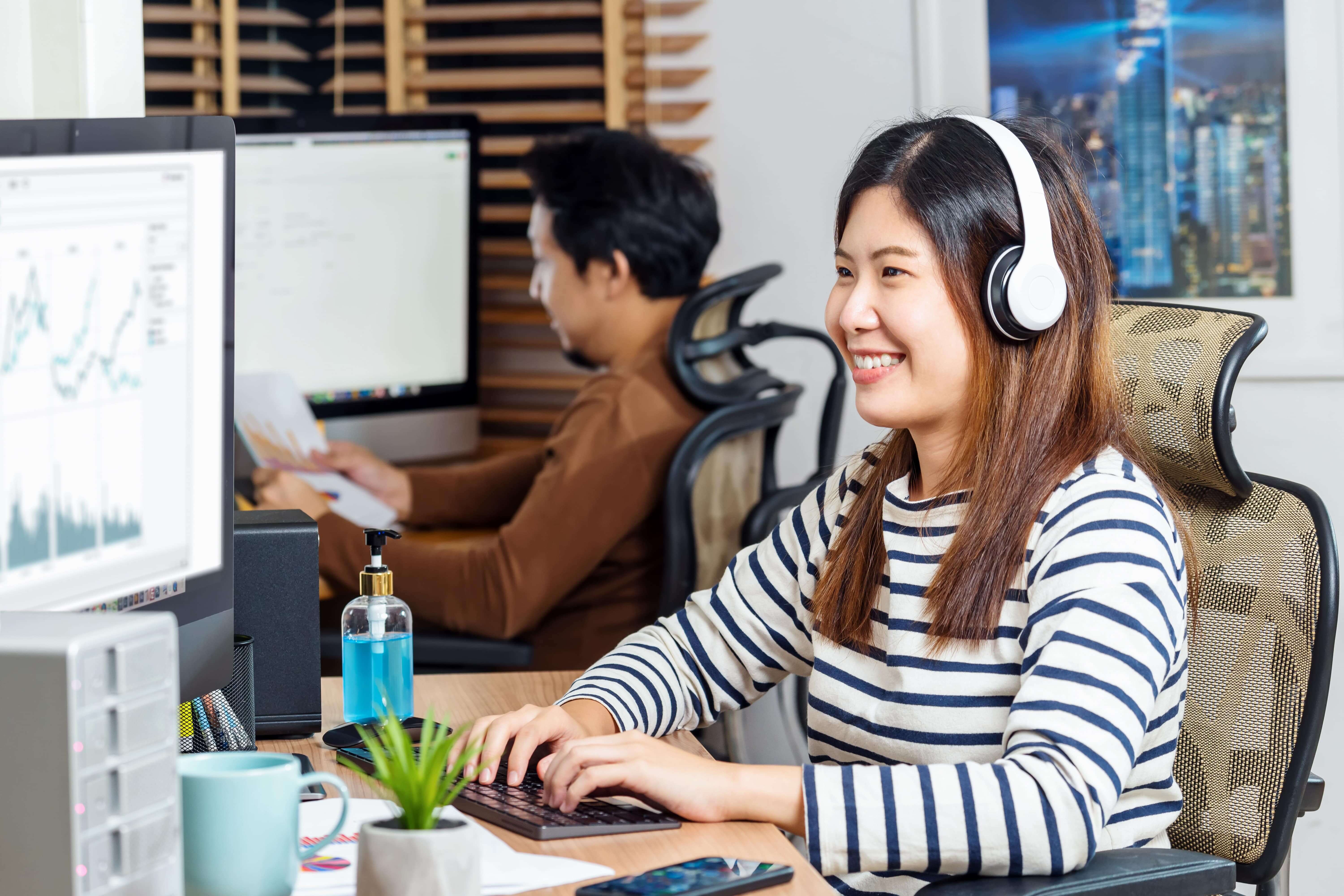 couple-of-asian-colleagues-smiling-and-working