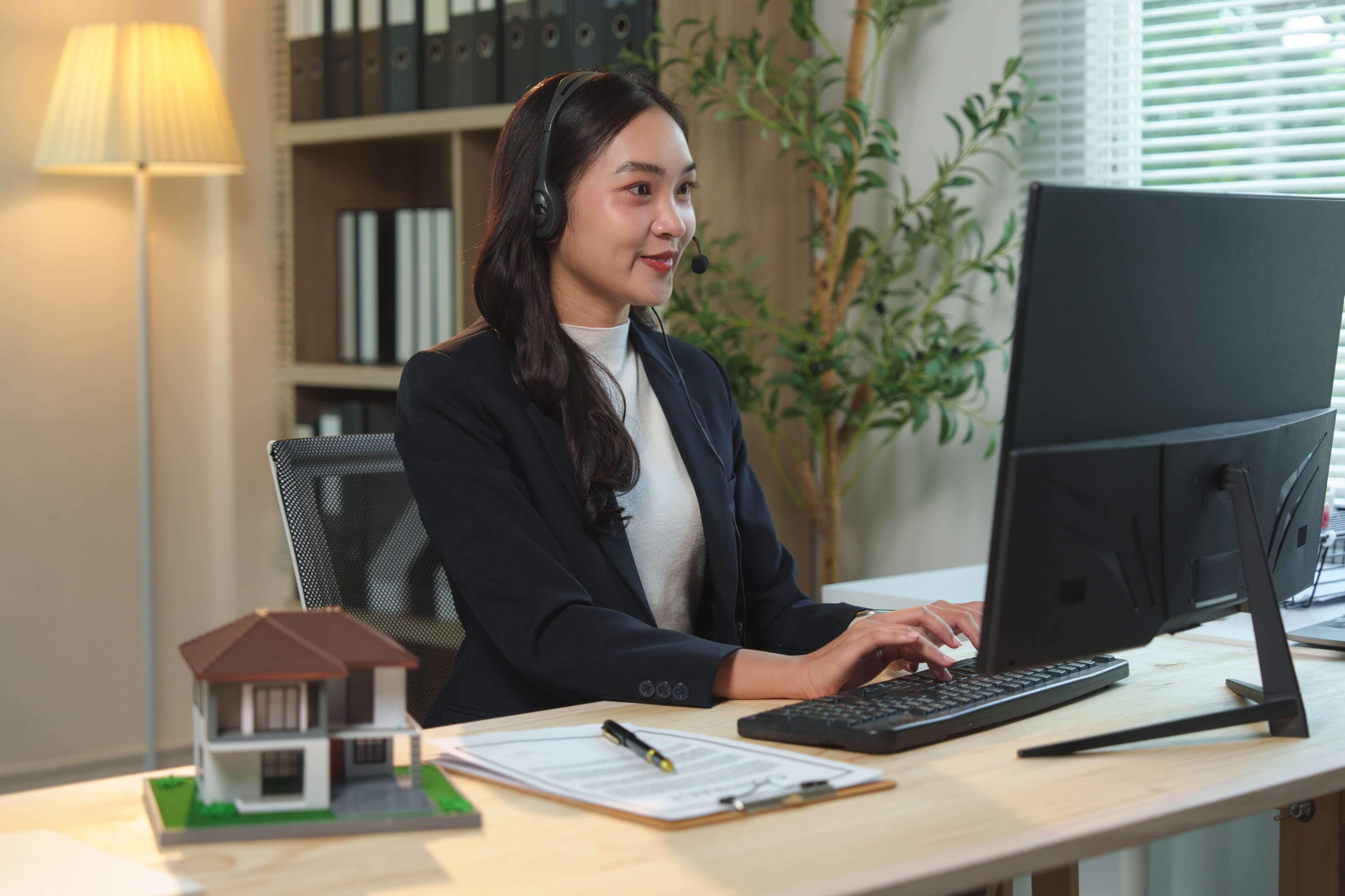 asian-real-estate-agent-wearing-headset-and-working
