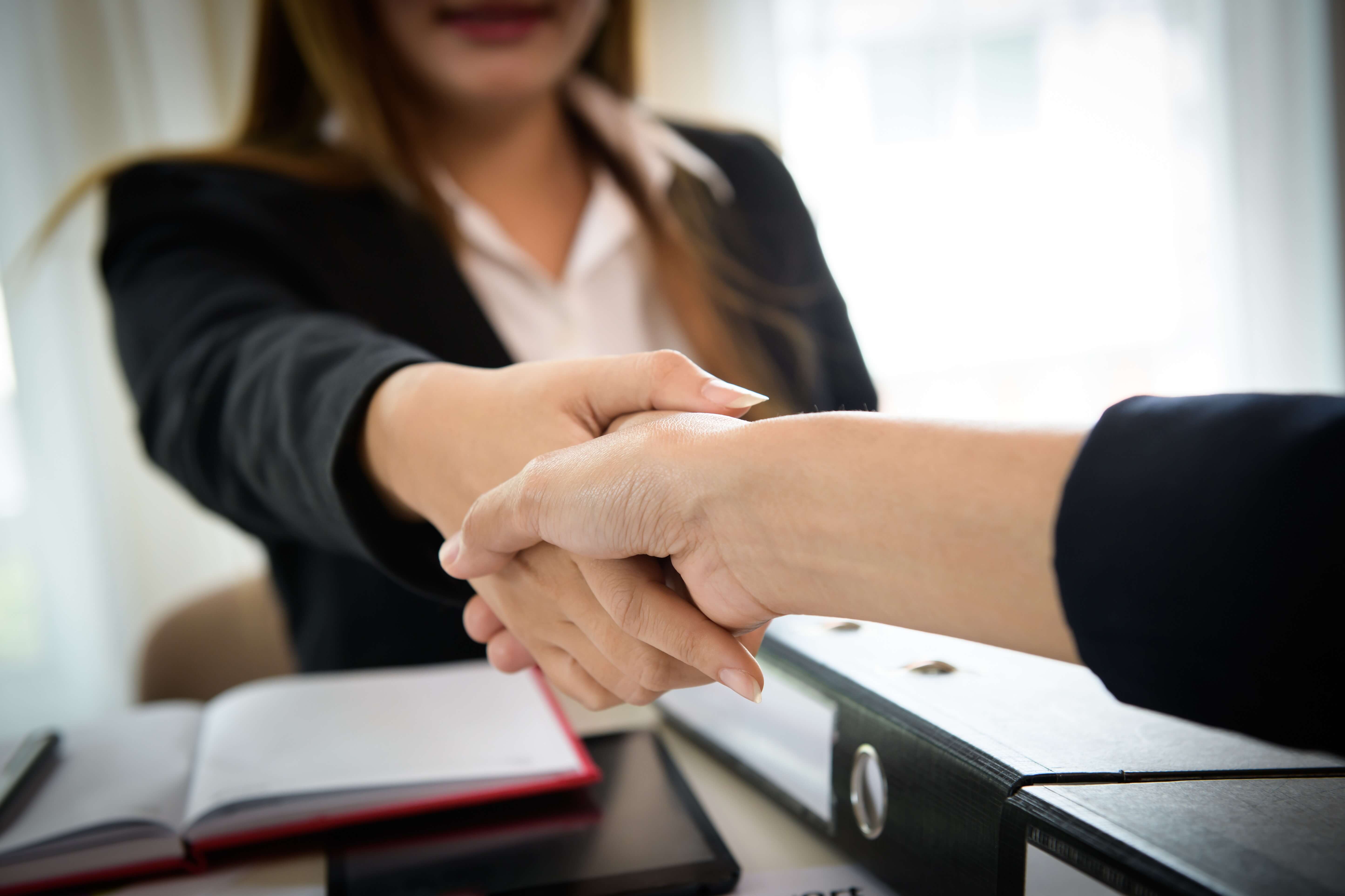 business-people-shaking-hands-while-sitting-at-the-working-place-finish-success-business-good