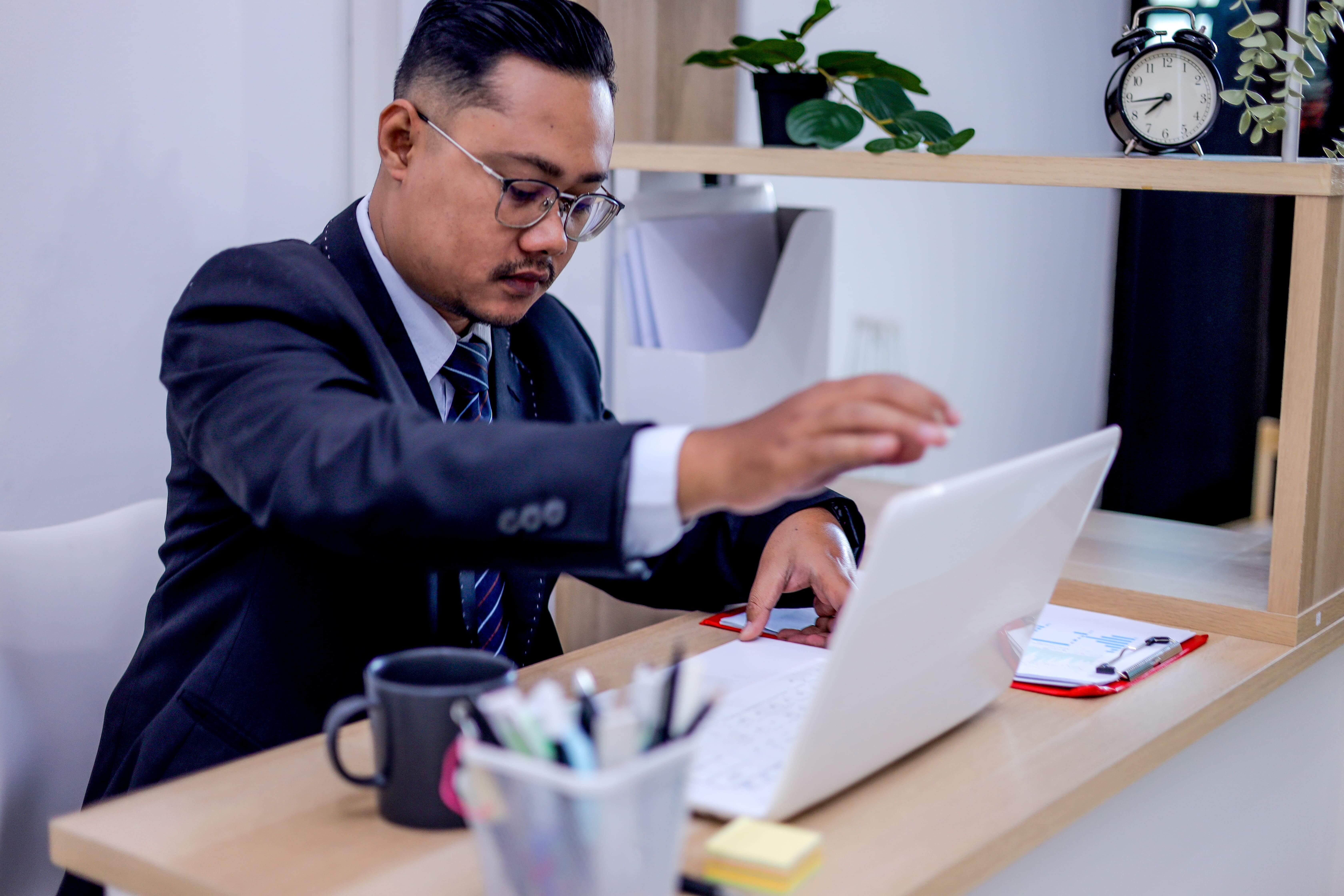 businessman-urgently-types-on-laptop-at-desk