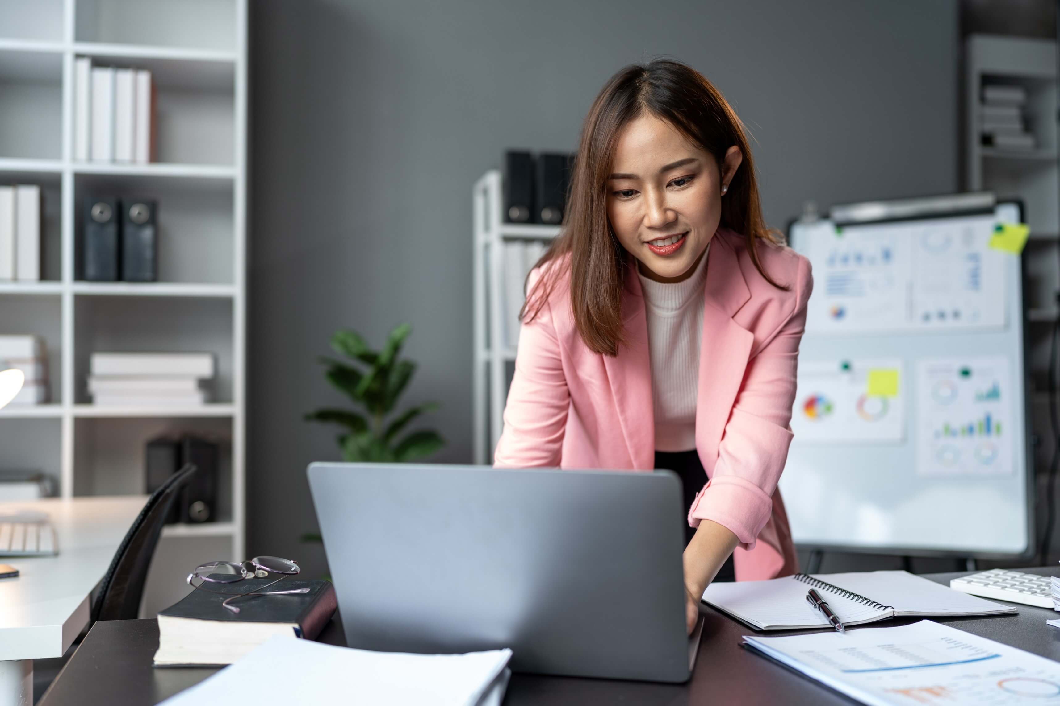 asian businesswoman typing on a laptop computer keyboard to work on finance