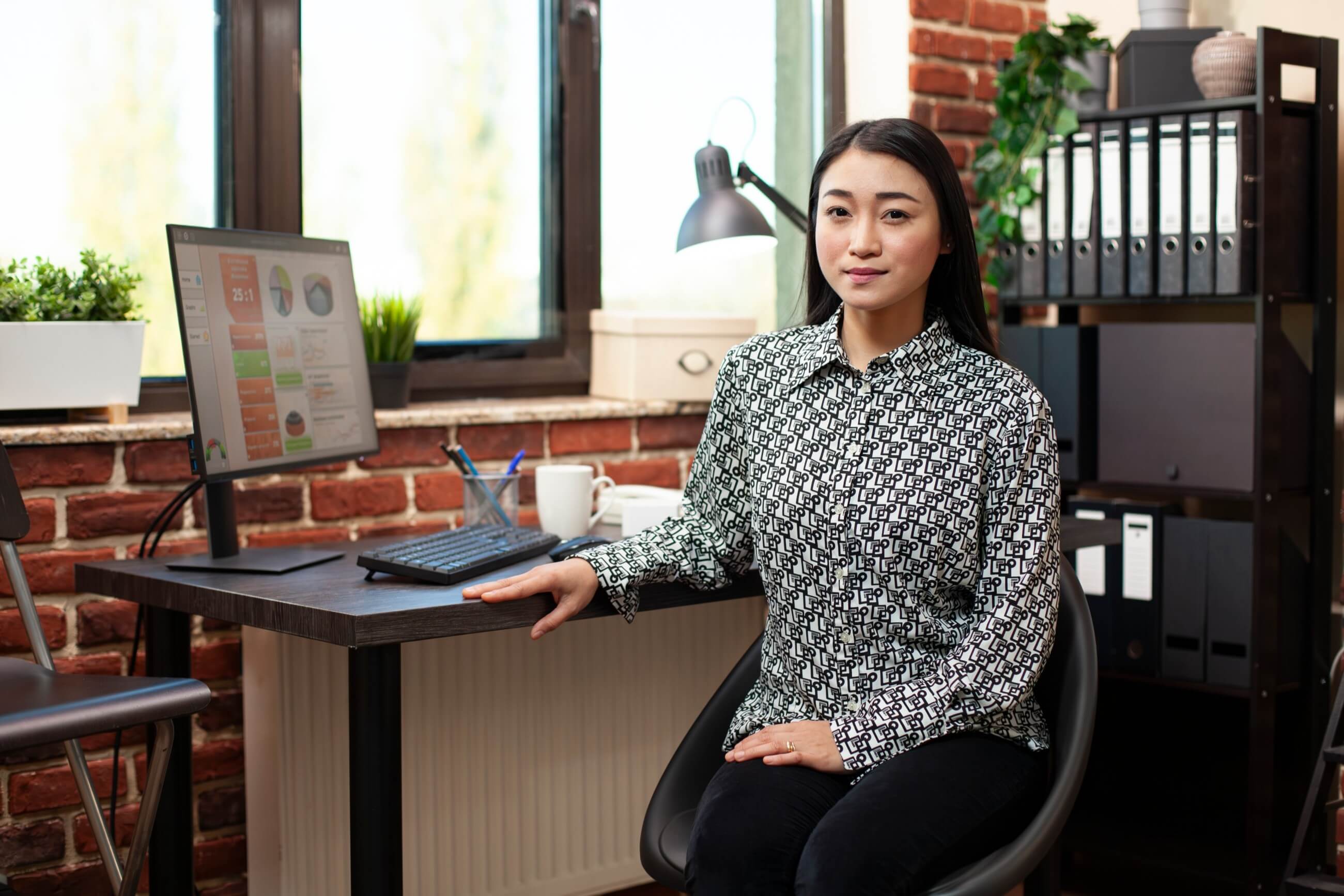 asian woman employee looking at camera in office