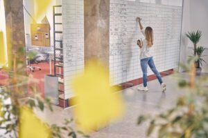 female-office-worker-writing-on-planner-task-board