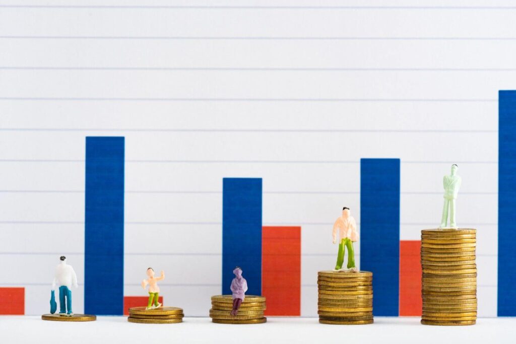 people-figures-on-coins-on-white-surface-with-graphs-at-background-concept-of-financial-equality