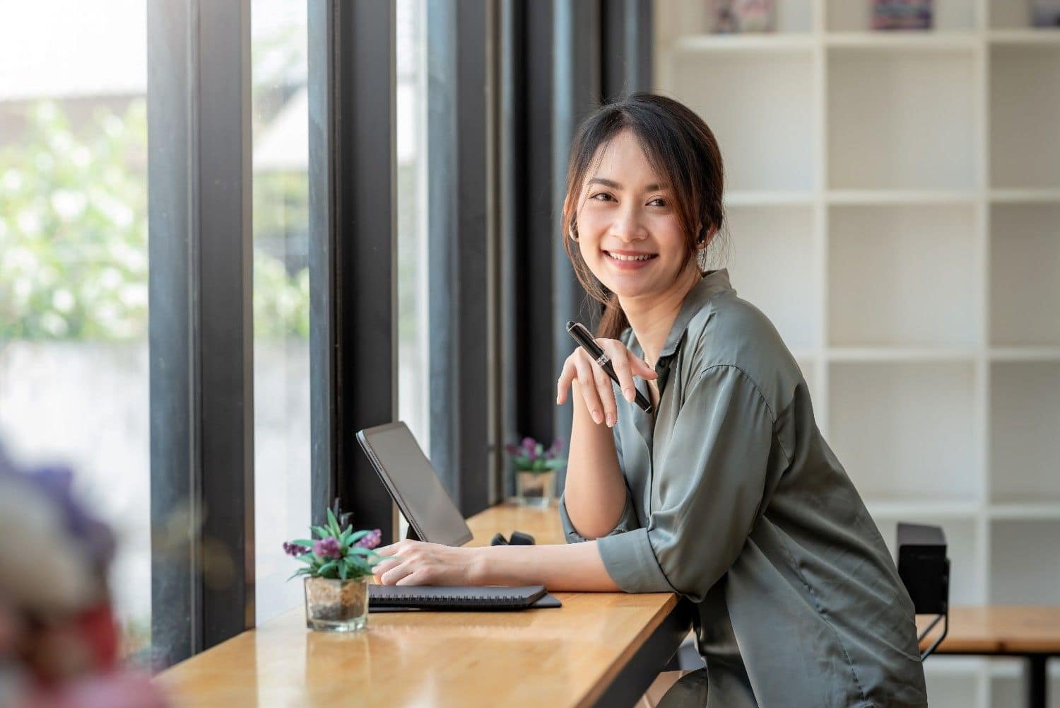 Smiling Asian businesswoman working at a desk on a laptop