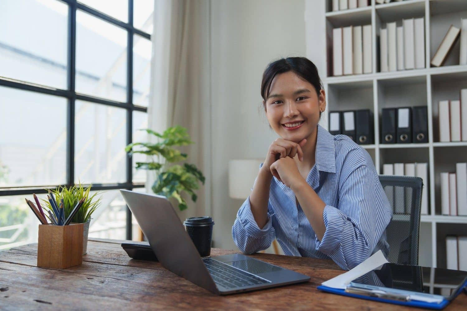 Young businesswoman doing remote work on a laptop in a cafe