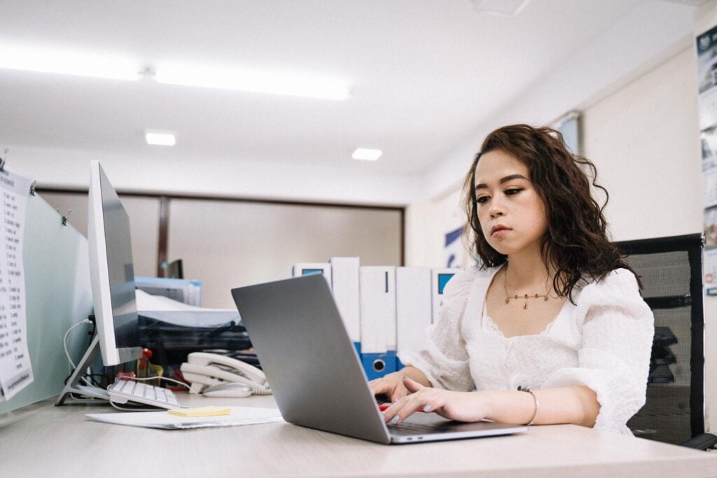 Corporate woman typing laptop office desk