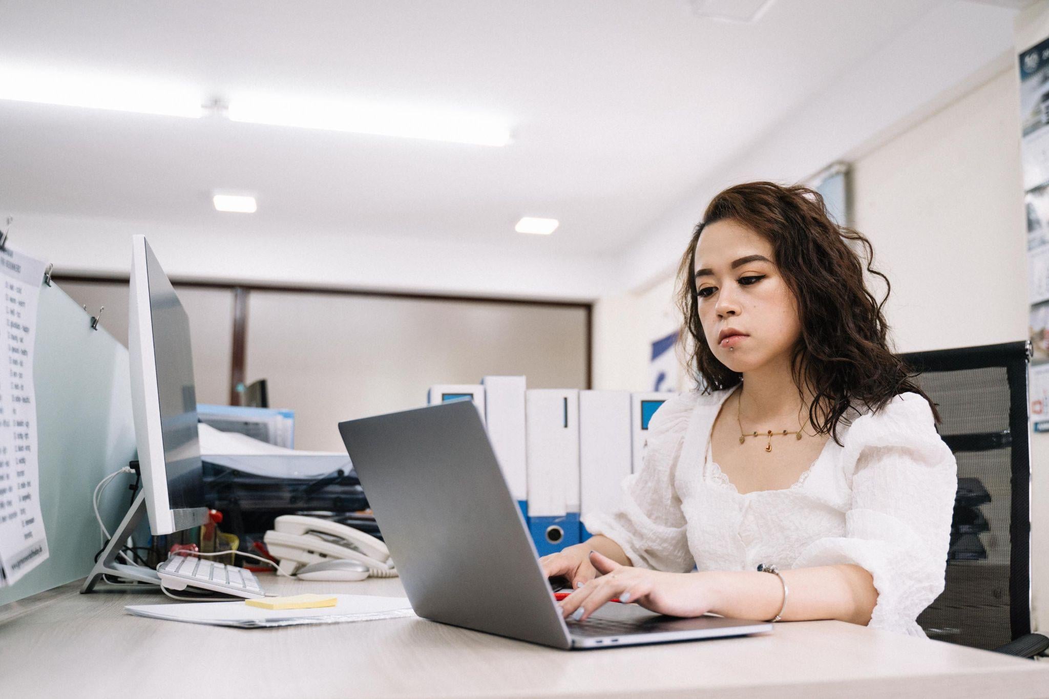 Corporate woman typing laptop office desk