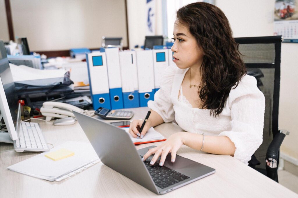 Focused office worker typing taking notes