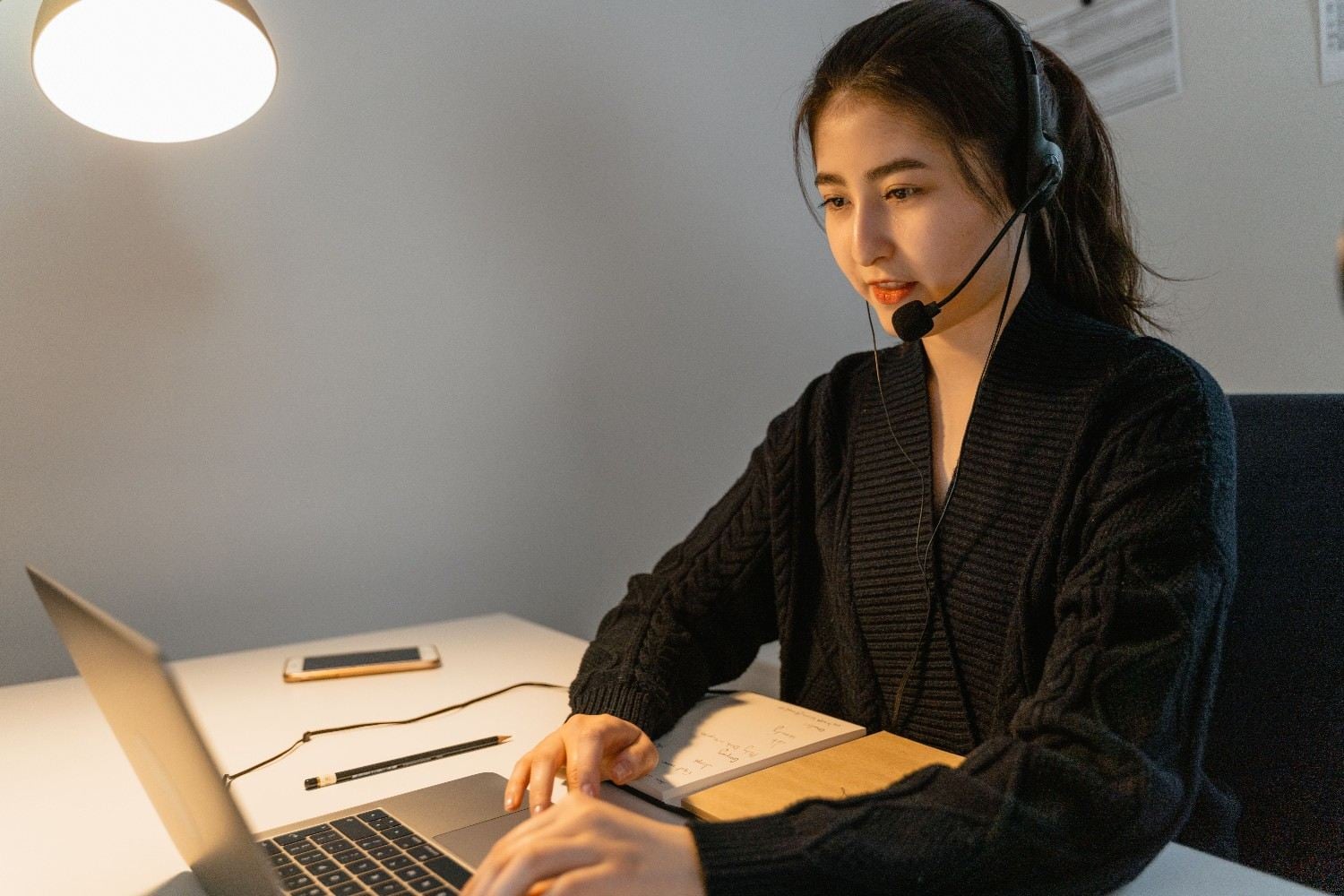Remote help desk agent typing on laptop