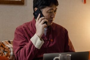 Business owner on a phone call at a laptop while coordinating a campaign launch