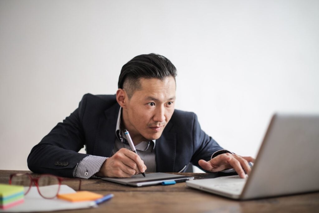 Asian creative director editing on laptop