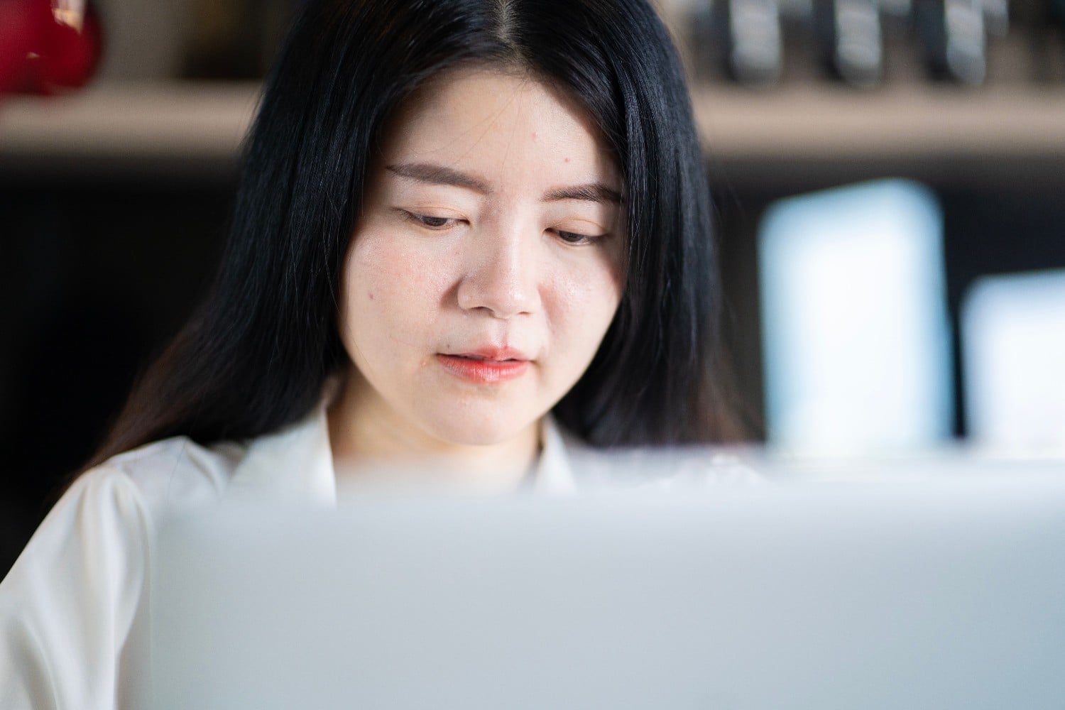 Asian data entry specialist at desk close up