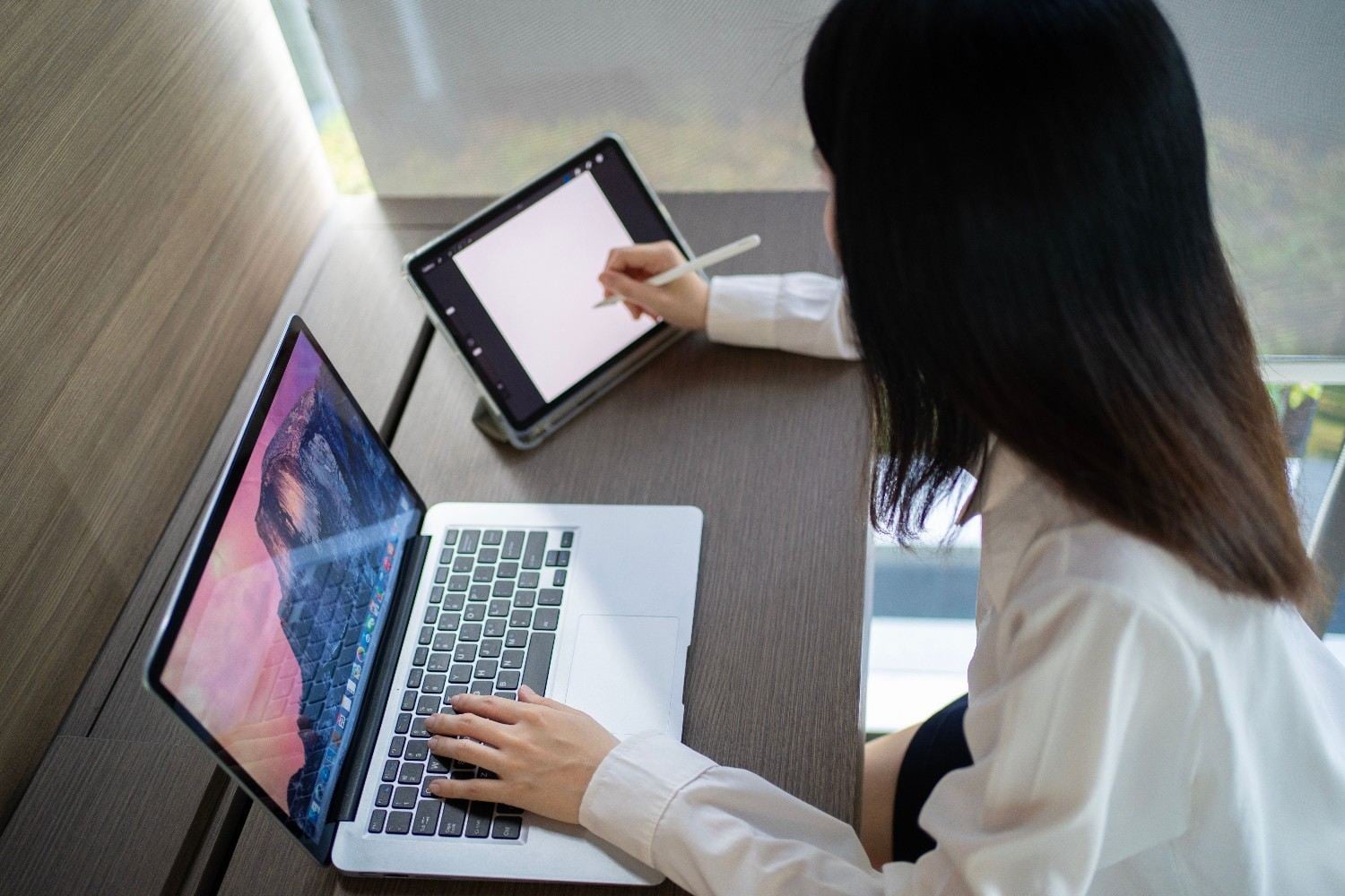 Digital content creator drawing on tablet at desk